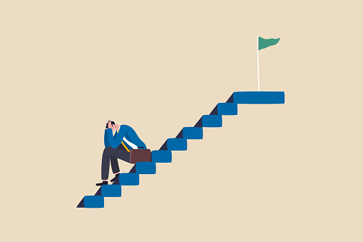 Fear of failure, anxiety or stressed, negative emotion in career development, afraid of progress forward or middle life crisis concept, depressed businessman sitting alone on stairway to success goal.