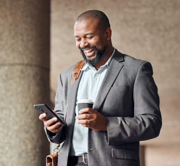 Shot of a mature businessman using his smartphone to send a text message while drinking coffee Business keeps getting better and better africa travel stock pictures, royalty-free photos & images
