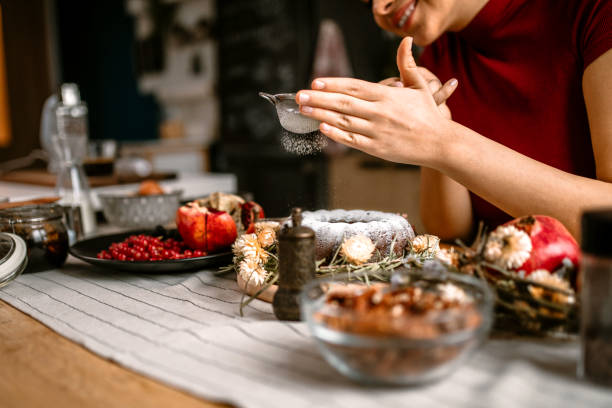 istock Woman decorating cake with powdered sugar and nuts 1366583294