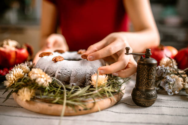 istock Woman decorating cake with chopped pecan nuts. 1366583357