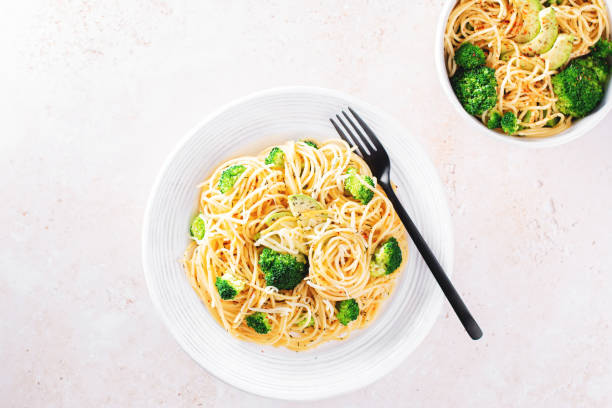 istock Broccoli and avocado pasta with grated cheese on stone background 1366583401