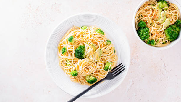 istock Broccoli and avocado pasta with grated cheese on stone background 1366583404