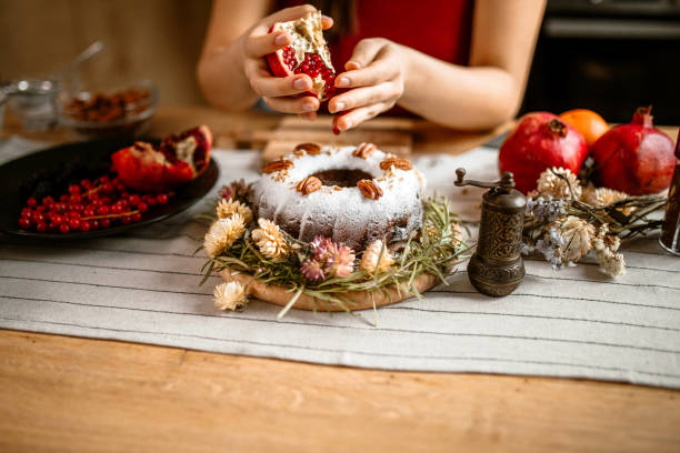 istock Woman decorating cake with pomegranate seeds. 1366583591