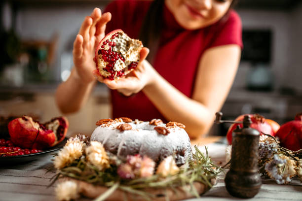 istock Woman decorating cake with pomegranate seeds. 1366583595