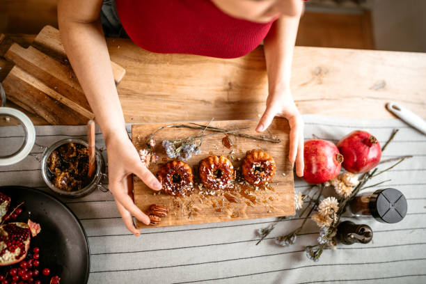 Woman serving honey doughnut muffins on serving wooden board