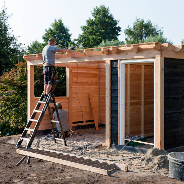 Two men building a domestic wooden garden shed Wierden, Twente, Overijssel, Netherlands, july 26th 2018,  two men building a domestic wooden garden shed in a back yard on a sunny summer day, one is  standing on a ladder mounting timber on the roof, the other is working on the ground, making preparations for electricity - having a garden shed in the back yard is becoming more and more common in the Dutch suburbs shed stock pictures, royalty-free photos & images