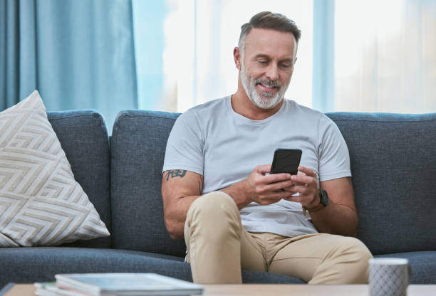istock Shot of a mature man relaxing at home while using his smartphone 1366584859