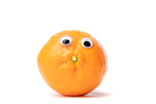 A humorous image of an orange with googly eyes looking like it's puckering up for a kiss.