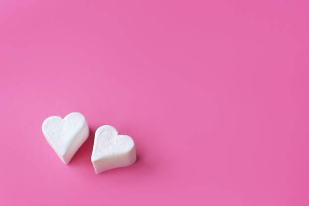 istock Minimalist Valentine's day. White marshmallow hearts on pink pastel background. Composition for Valentins Day, Mother's Day, March 8 or Women's Day. 1366586256