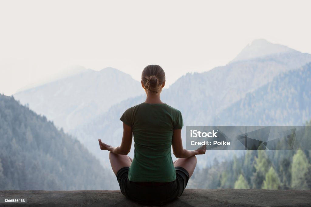 Woman practicing yoga in a mountains. Meditation and harmony concept - Royalty-free Zen Stockfoto