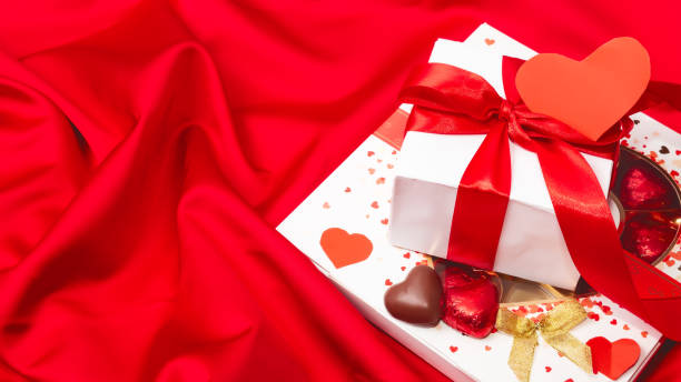 istock Gift and sweets heart on a red satiny background. valentine's day. concept 1366587116
