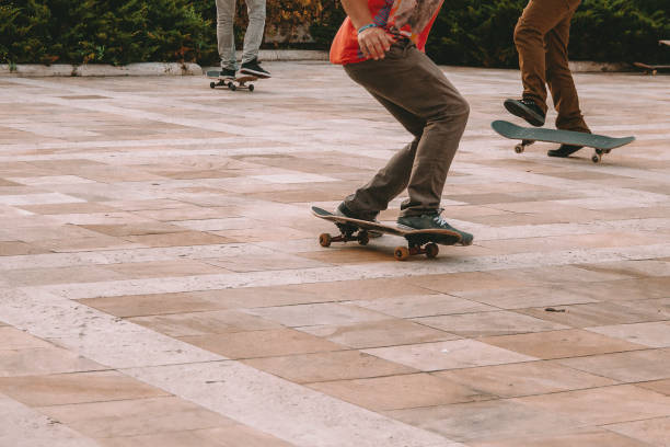 Just legs of three guys skateboarding in a square
