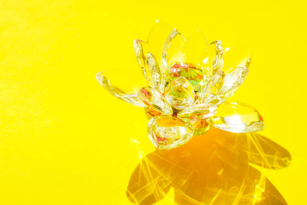 Crystal lotus flower on a yellow sunny table.