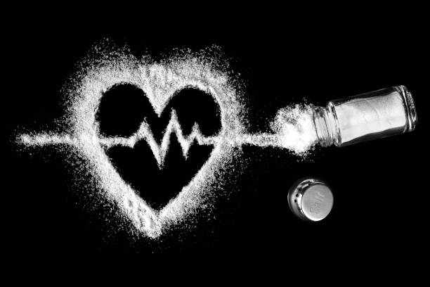 heart, cardiogram, salt and salt shaker on black background - salting imagens e fotografias de stock