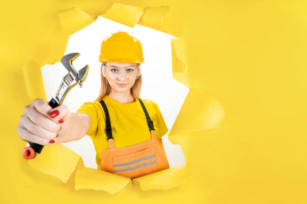 istock Woman in uniform builder holding metal wrench 1366588553