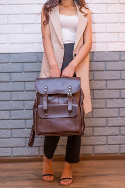 istock Woman holding brown leather backpack in the hand 1366589883