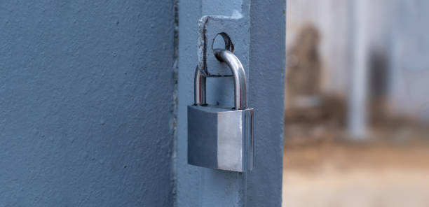 istock Heavy metal padlock on an open entrance gate, closeup view 1366591392