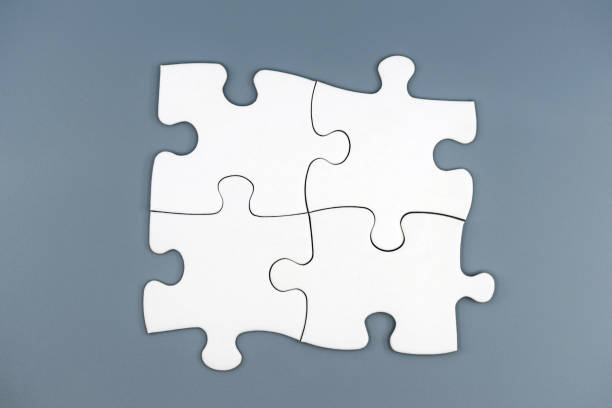 istock Four white puzzle pieces on gray background 1366591768