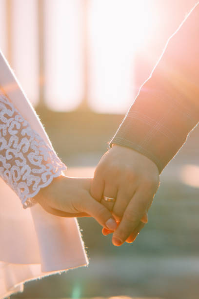 istock Bride and groom hold hands with golden ring on finger. 1366592219