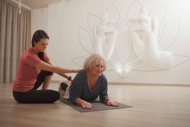 istock Senior woman training with yoga instructor 1366593148