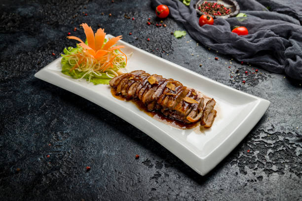 istock Peking duck on plate on dark stone table, Chinese cuisine 1366595157