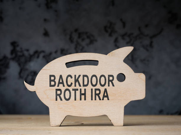 Wooden piggy bank with words backdoor Roth IRA. A Wooden piggy bank with words backdoor Roth IRA. back door stock pictures, royalty-free photos & images