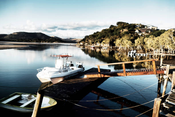 Motor boat and canoe moored to a jetty on a river