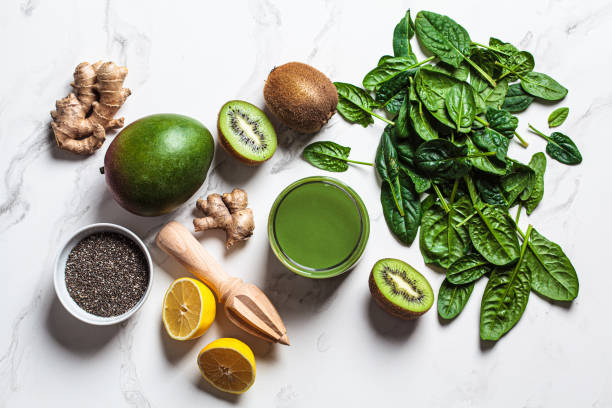 istock Green spinach and mango smoothie with ingredients on white marble background. Detox drinks concept. 1366600084