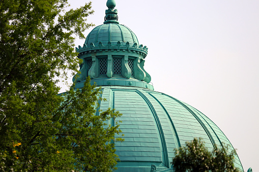 Old architecture dome roof design made by copper, photograph taken under the sun shine. Green-blue domed copper roof design of Western-style buildings in Tokyo.