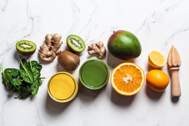 istock Yellow mango smoothie and green spinach smoothie with ingredients on white background. Detox drinks concept. 1366600302