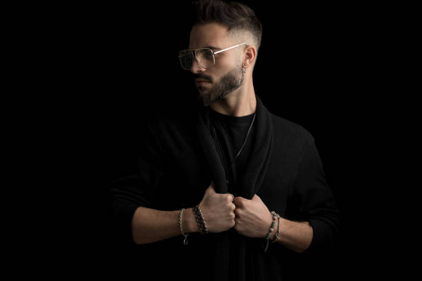 istock sexy unshaved young man looking to side and holding black jacket 1366601362