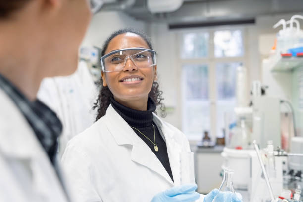 istock Scientist discussing with male colleague while working in a lab 1366602018
