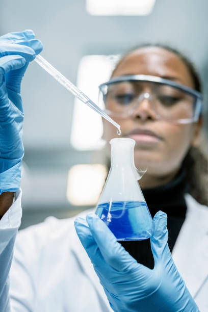 istock Scientist in protective workwear mixing chemicals in laboratory 1366602064