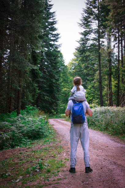 istock Father walks with his daughter in the forest 1366602065