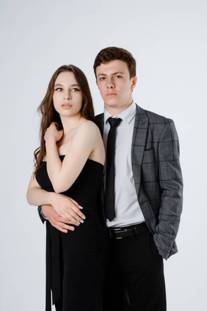 istock young couple in suits on white background. 1366602196