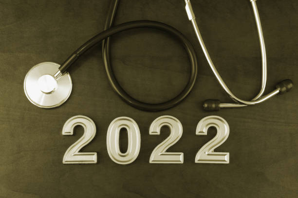 istock Stethoscope and numbers 2022 on wooden table. 1366603454