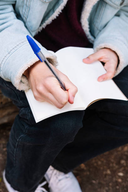 istock Close-up of a woman's hands writing in a notebook. 1366605133