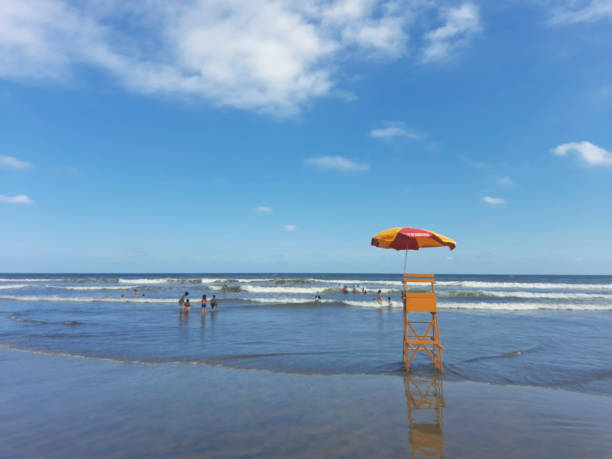 Mongaguá, SP, Brazil - January 21, 2021: Bathers in the sea in front of a lifeguard chair on a summer day