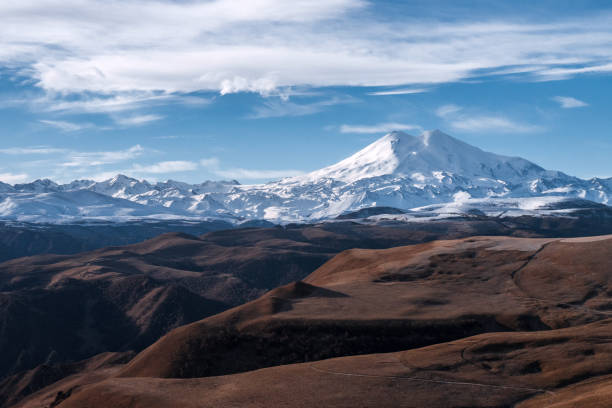 istock Great nature mountain range. Amazing perspective of  Elbrus with autumn fields, blue sky background. 1366606134