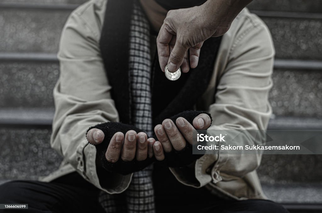 Close-up of the poor or homeless Homeless people ask for money in public. The poor beggar in the city sat on the stairs with a silver mug. Begging - Social Issue Stock Photo