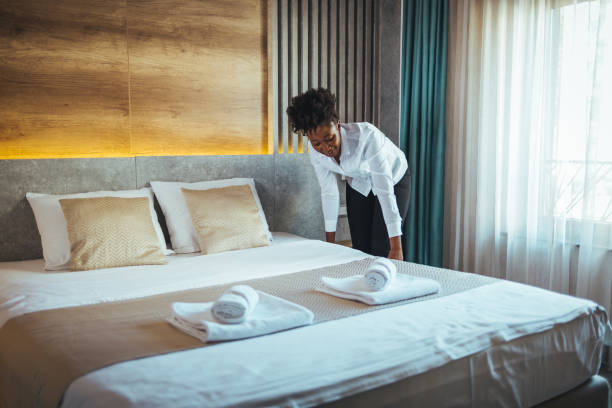istock Maid making bed in hotel room. 1366606637