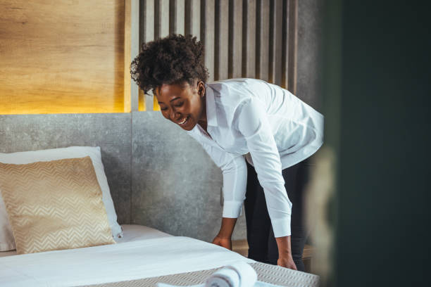 istock African maid making bed in hotel room. 1366606746