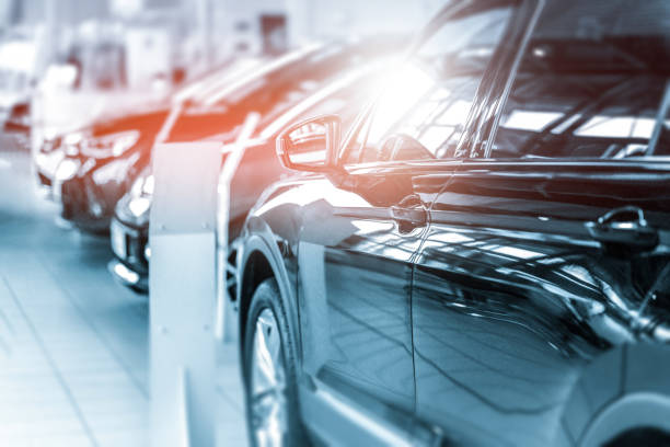 New cars at dealer showroom. New cars at dealer showroom. Blurred background. Fokus is on the handle from the left car empty dealership interior stock pictures, royalty-free photos & images