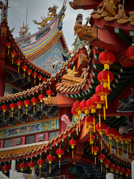 istock Two Curved Roofs of a Temple with Hanging Red  Lanterns 1366608279