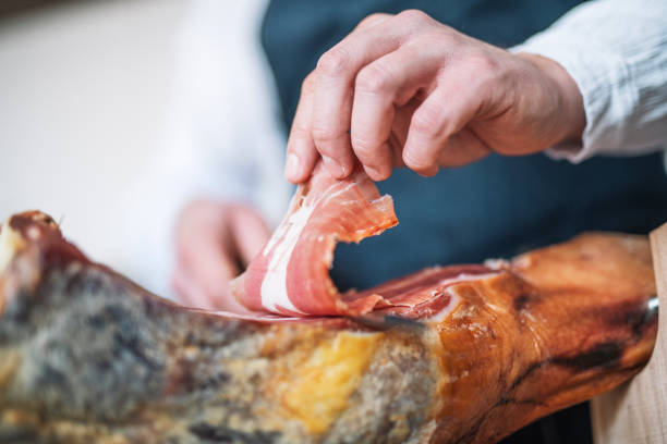 шеф-повар режет испанскую ветчину серрано. - ham kitchen knife meat iberian стоковые фото и изображения