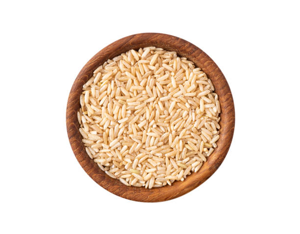 istock Bowl with brown rice isolated on white background. Close-up. Grain rice on white background. Top view, image with copy space. 1366609645