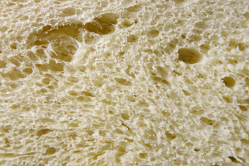 Close up of slice of freshly baked wheat bread. Abstract food background with texture of bread.
