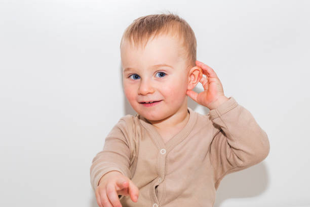 Boy raised his hand to his ear stock photo