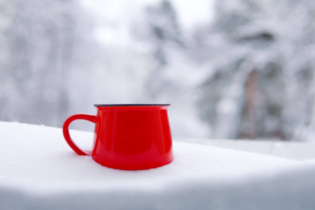 istock Red mug with tea and coffee in the snow 1366613866