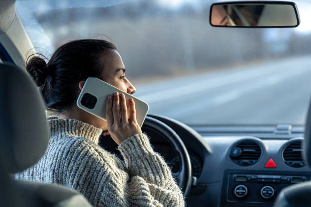 mujer joven hablando por teléfono mientras conduce un automóvil. - driving car distracted accident fotografías e imágenes de stock